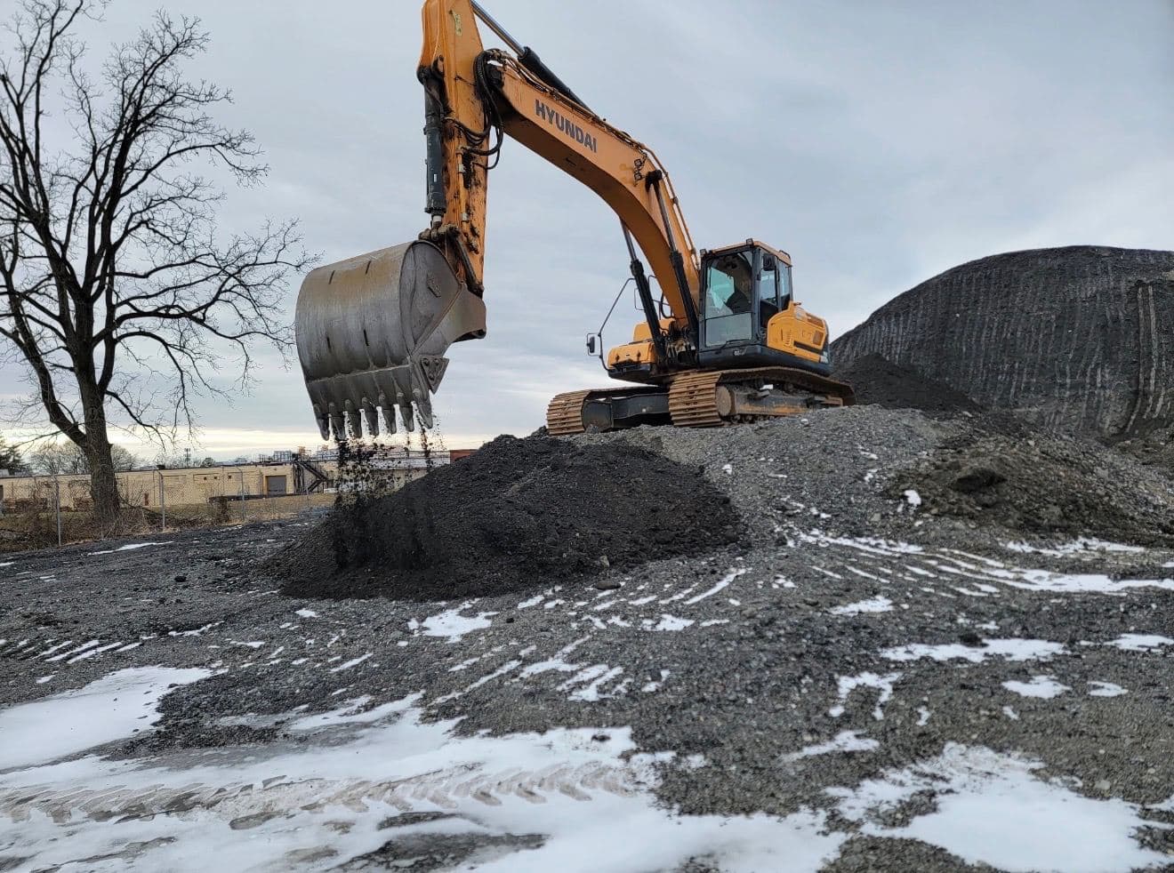 Hyundai excavator working a screened material pile
