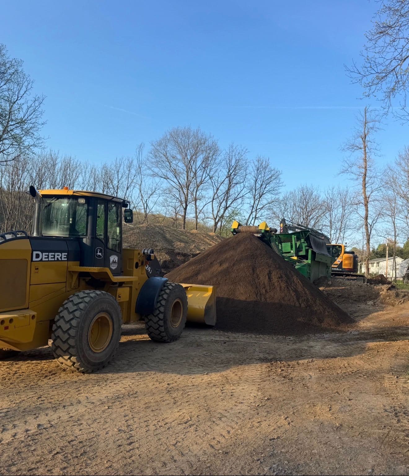 John Deere wheel loader and screener producing screened topsoil
